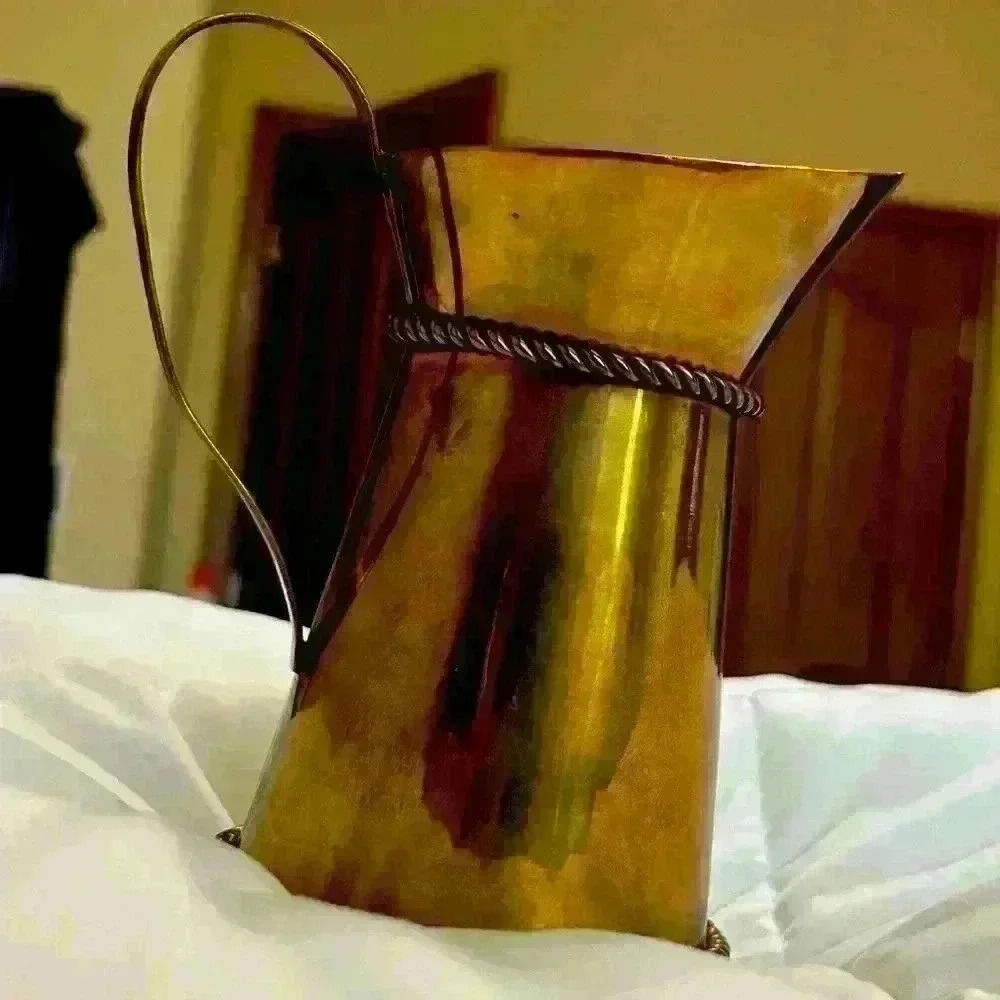 Brass pitcher with braided rope design wrapped around it made in India. Vintage
